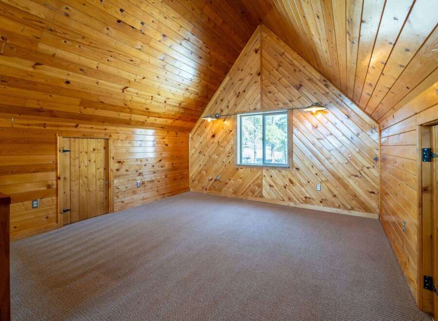 Step into this charming cabin-style room, featuring stunning wooden walls and ceilings that create a warm and inviting atmosphere.
