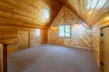 Step into this charming cabin-style room, featuring stunning wooden walls and ceilings that create a warm and inviting atmosphere.
