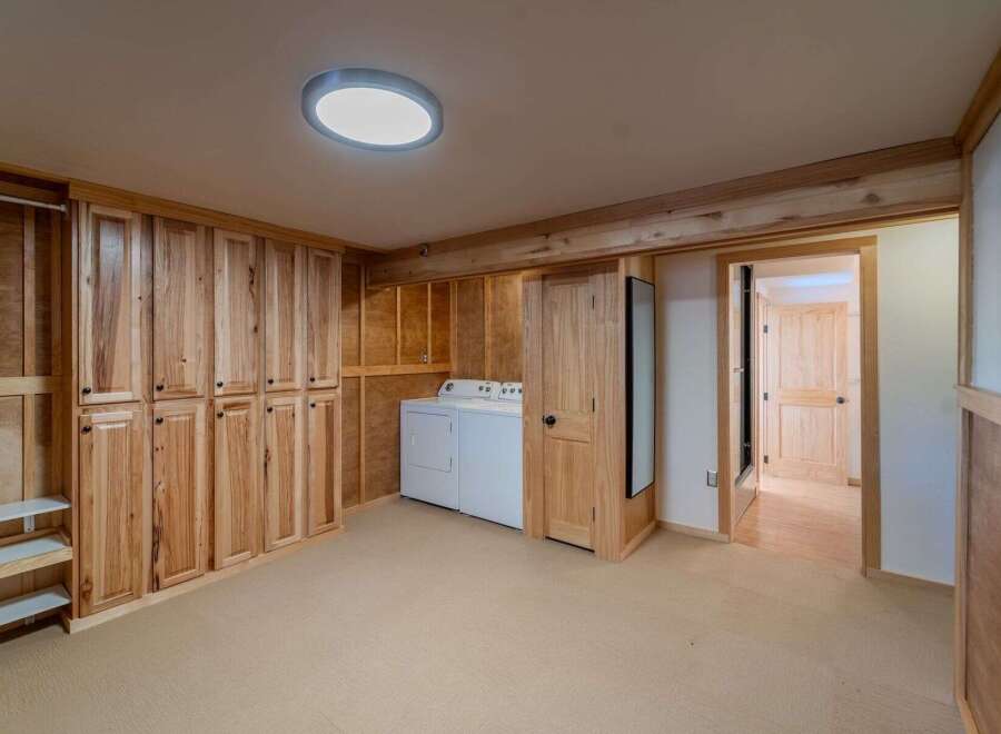This stunning property boasts a spacious laundry room with ample storage and a modern design.