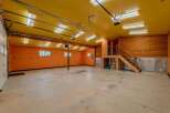 This spacious garage offers ample room for vehicles and storage, featuring a vibrant orange interior and a bright yellow ceiling.