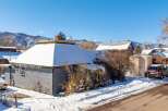 Nestled in a serene winter landscape, this charming property boasts a snow-covered roof and a cozy ambiance.