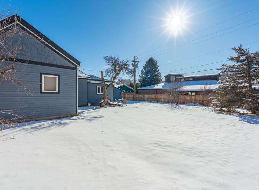 Discover the charm of this property, featuring a spacious backyard blanketed in fresh snow.