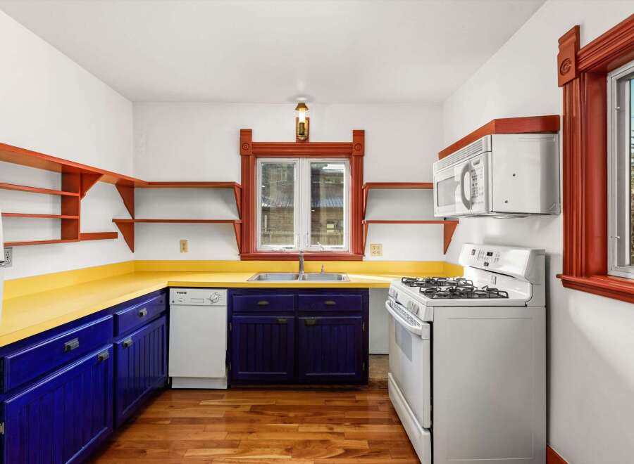 Step into this charming kitchen, featuring a vibrant yellow countertop and striking blue cabinetry.