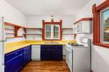 Step into this charming kitchen, featuring a vibrant yellow countertop and striking blue cabinetry.