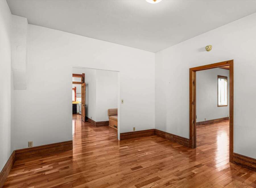 Step into this inviting space with gleaming hardwood floors and crisp white walls.