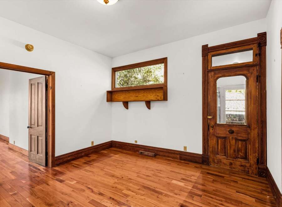 Step into a charming space with original hardwood floors and intricate wooden door frames.