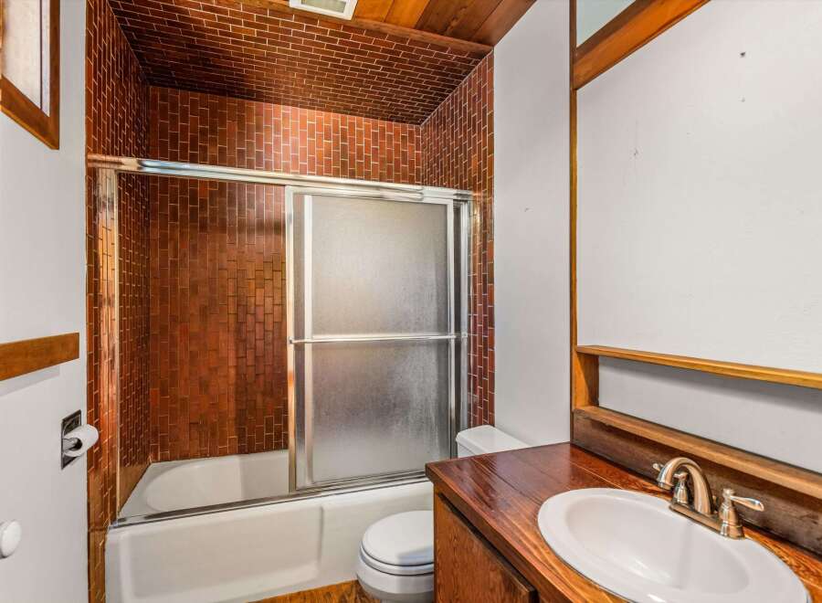 Step into this charming bathroom featuring a unique brick-style tile design that adds character and warmth.