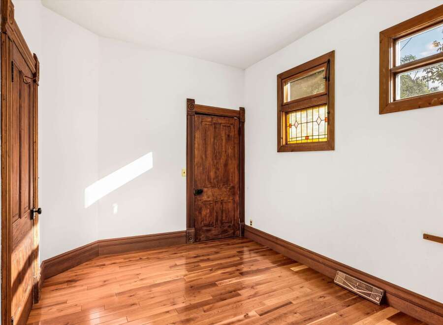 Step into this charming space featuring original hardwood floors and a beautifully crafted wooden door.