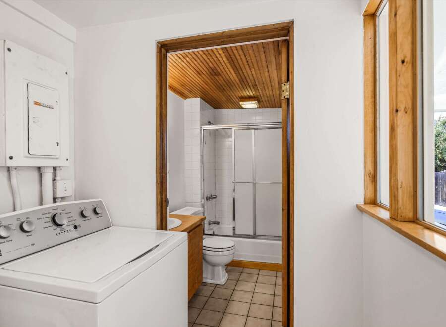This charming property features a well-lit laundry area with a modern washing machine.