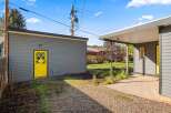 This charming property boasts a striking exterior with a vibrant yellow door, adding a pop of color to the gray siding.