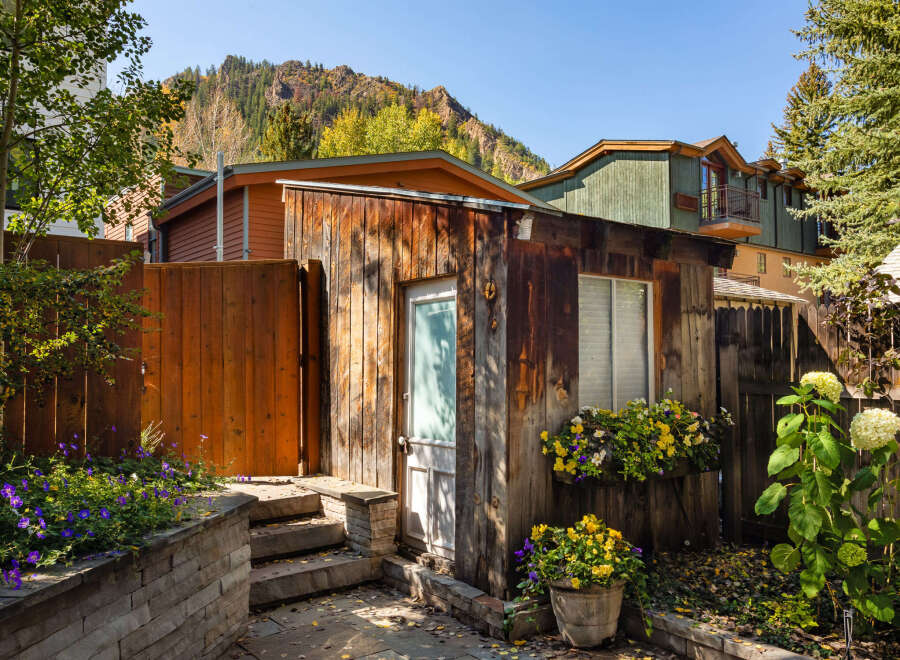 This charming property boasts a rustic exterior with a wooden facade and a welcoming entrance.