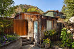 This charming property boasts a rustic exterior with a wooden facade and a welcoming entrance.