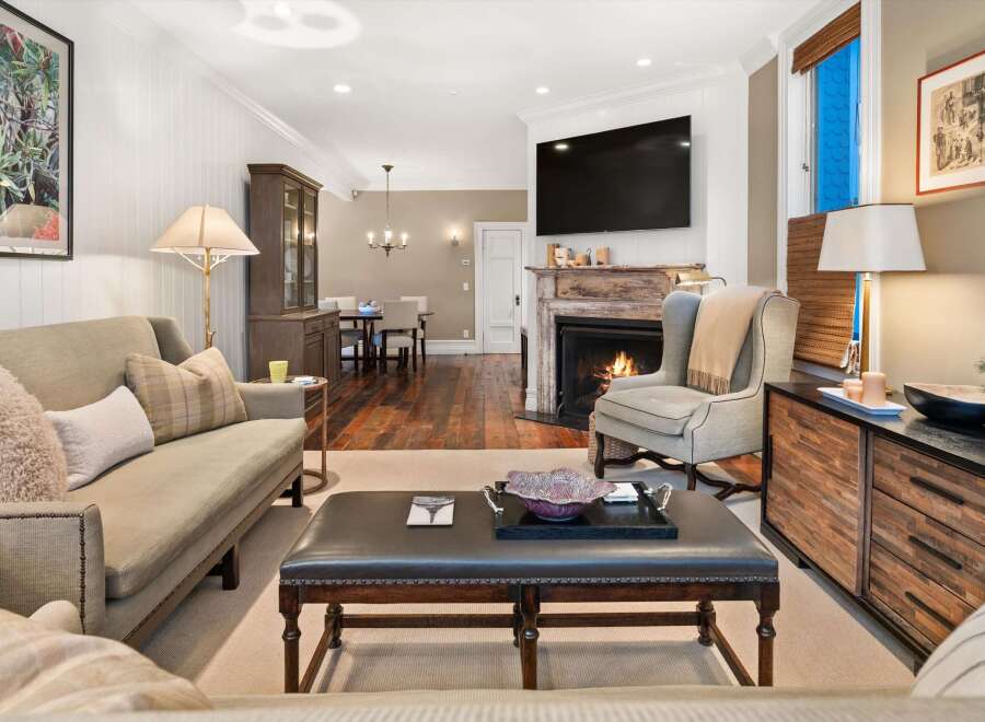 Step into luxury with this stunning living room, featuring a cozy fireplace and a sleek, modern TV.