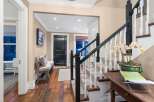 Step into luxury with this stunning entryway, showcasing a beautiful staircase with white balusters and a dark wood handrail.