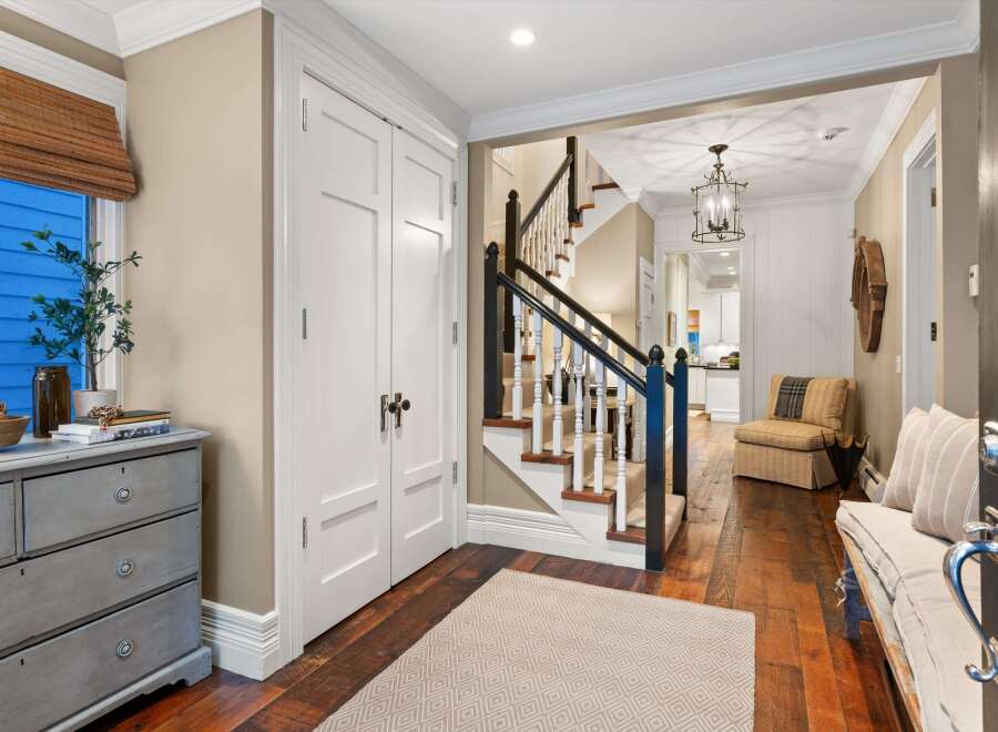 Step into this inviting entryway, showcasing a beautiful staircase and hardwood floors.