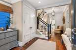 Step into this inviting entryway, showcasing a beautiful staircase and hardwood floors.