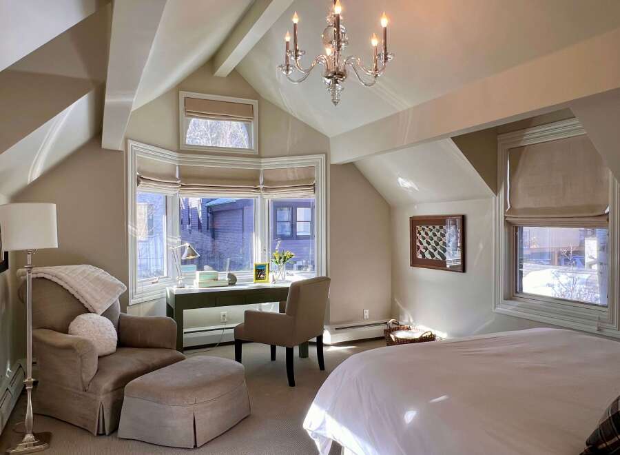 Step into this elegant bedroom, where natural light floods through the expansive windows, illuminating the space.