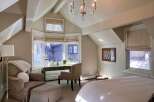 Step into this elegant bedroom, where natural light floods through the expansive windows, illuminating the space.