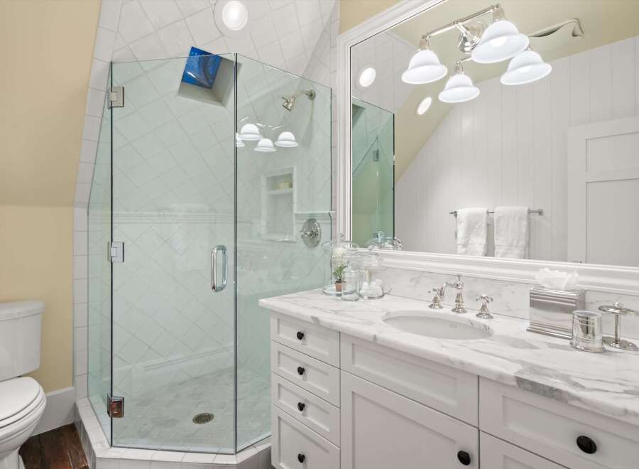 Step into luxury with this stunning bathroom featuring a glass-enclosed shower and elegant marble countertops.