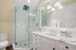 Step into luxury with this stunning bathroom featuring a glass-enclosed shower and elegant marble countertops.