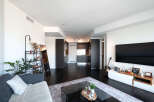 This stunning modern apartment boasts an open-concept living space with dark hardwood floors and sleek, contemporary design.