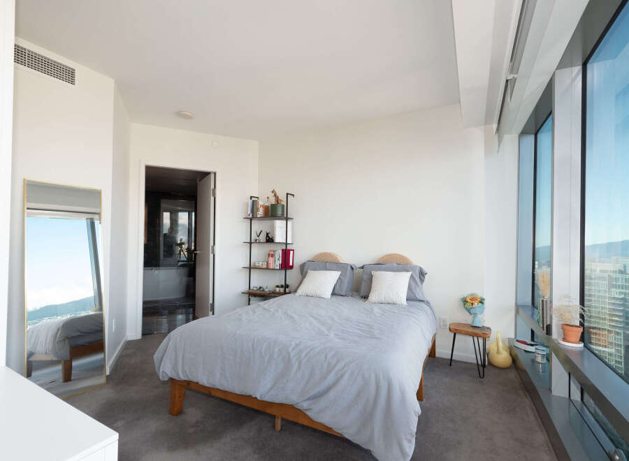 Experience luxury living in this stunning bedroom with breathtaking city views.