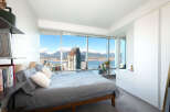 Experience luxury living in this stunning bedroom with breathtaking city and mountain views.