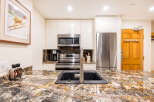 This stunning kitchen boasts modern appliances and elegant granite countertops, perfect for culinary enthusiasts.