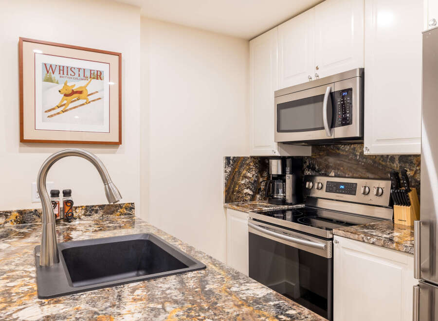 This stunning kitchen boasts modern appliances and elegant granite countertops, perfect for culinary enthusiasts.