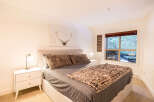This cozy bedroom features a comfortable bed with plush pillows and a stylish faux fur throw.
