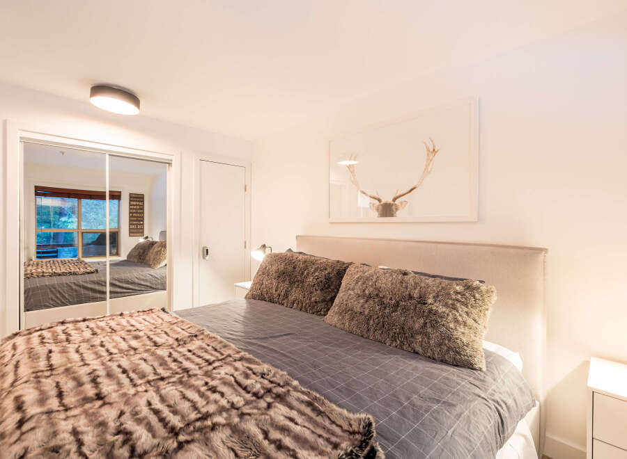 This cozy bedroom features a plush bed with a soft, textured blanket and pillows, creating a warm and inviting atmosphere.