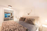 This cozy bedroom features a plush bed with a soft, textured blanket and pillows, creating a warm and inviting atmosphere.