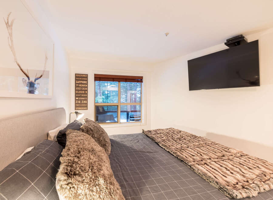 This cozy bedroom features a comfortable bed with plush pillows and a stylish faux fur throw, perfect for relaxing after a long day.