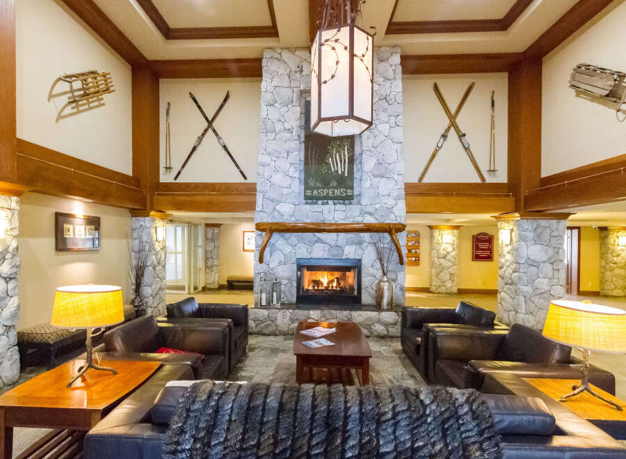 Step into the inviting ambiance of this luxurious lodge, featuring a cozy fireplace and comfortable seating areas.
