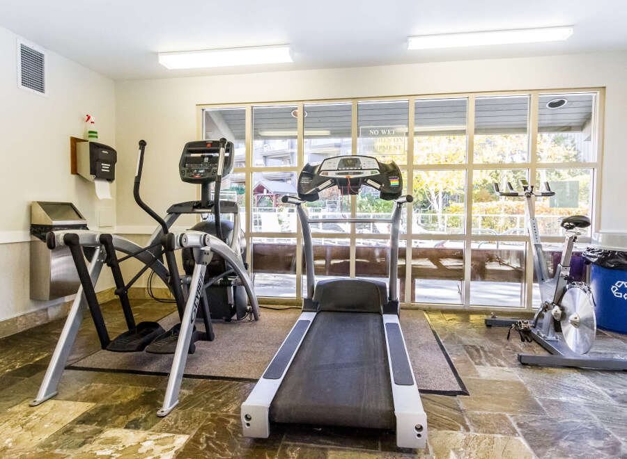 This well-equipped fitness center offers a variety of exercise machines, including a treadmill, elliptical, and stationary bike, perfect for a comprehensive workout.