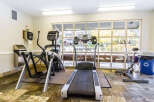 This well-equipped fitness center offers a variety of exercise machines, including a treadmill, elliptical, and stationary bike, perfect for a comprehensive workout.