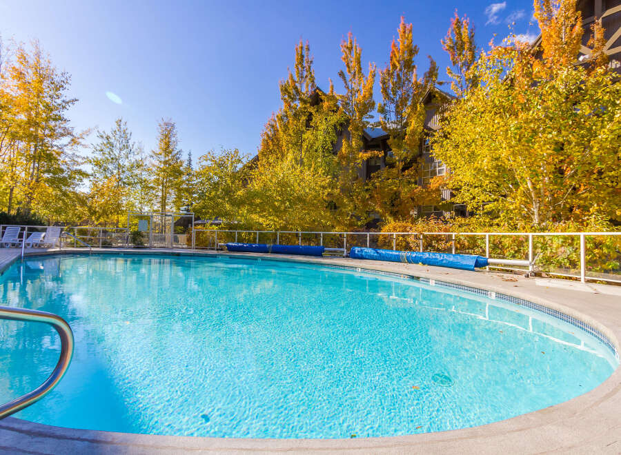 Enjoy the tranquility of this stunning outdoor pool surrounded by vibrant fall foliage.