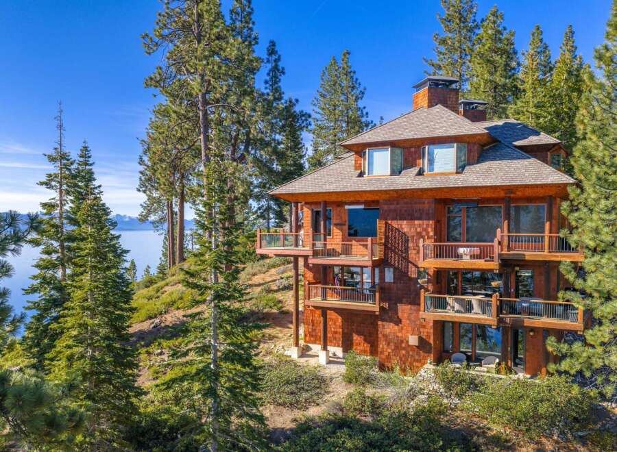 Nestled amidst towering pines, this stunning property offers breathtaking views of the lake.
