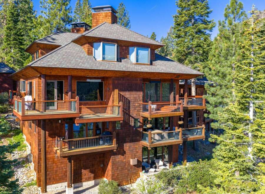 This stunning mountain home boasts a unique architectural design with multiple levels of balconies and decks, perfect for enjoying the surrounding natural beauty.