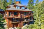 This stunning mountain home boasts a unique architectural design with multiple levels of balconies and decks, perfect for enjoying the surrounding natural beauty.