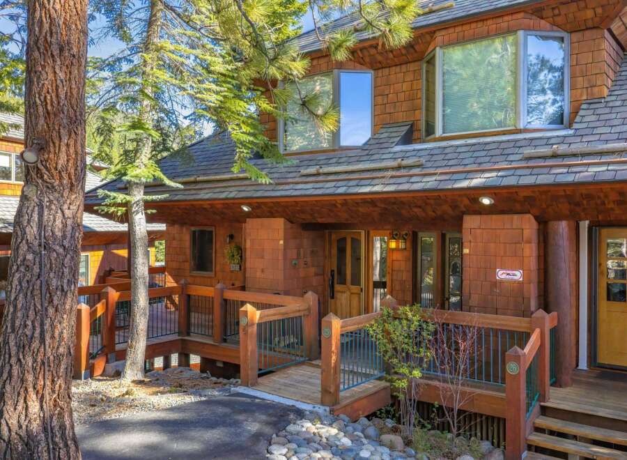 Nestled amidst lush greenery, this stunning property boasts a charming wooden exterior and a welcoming entrance.