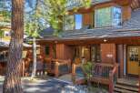 Nestled amidst lush greenery, this stunning property boasts a charming wooden exterior and a welcoming entrance.