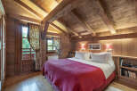 Experience the warmth and charm of this cozy bedroom, featuring stunning wooden beams and paneling that create a rustic ambiance.