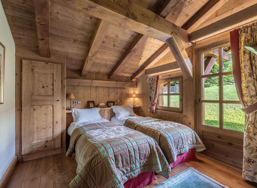 This charming bedroom features a rustic design with wooden walls and ceiling, creating a warm and inviting atmosphere.