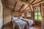 This charming bedroom features a rustic design with wooden walls and ceiling, creating a warm and inviting atmosphere.