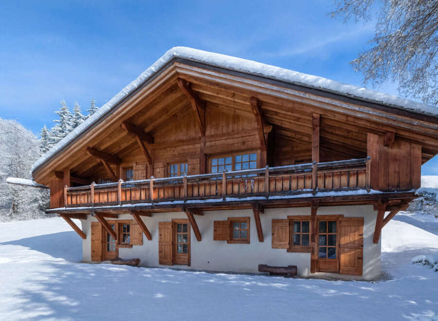 This stunning wooden chalet, nestled in a snowy landscape, offers a cozy retreat.