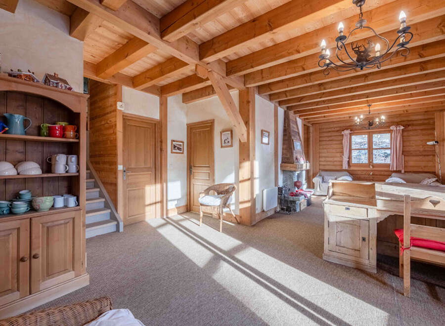 Step into this charming chalet-style home, boasting a warm and inviting interior with exposed wooden beams and paneling.
