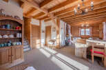 Step into this charming chalet-style home, boasting a warm and inviting interior with exposed wooden beams and paneling.