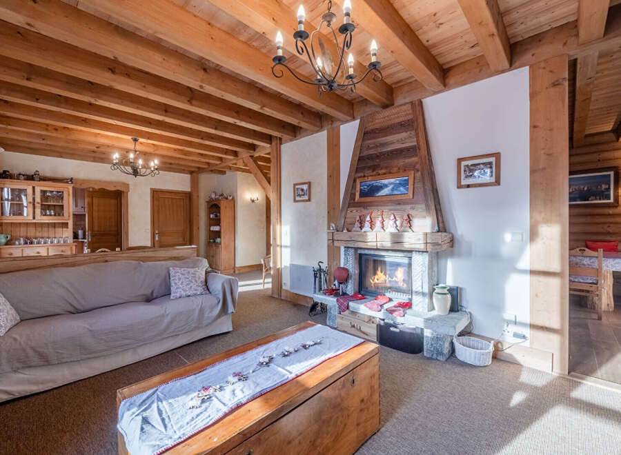 Experience the warmth and charm of this stunning property, featuring a cozy living room with a fireplace and exposed wooden beams.