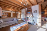 Experience the warmth and charm of this stunning property, featuring a cozy living room with a fireplace and exposed wooden beams.